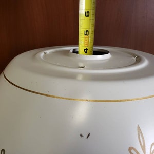 K&ouml;nnte beinhalten: Wei&szlig;e Deckenleuchte aus Metall mit goldener Verzierung und einem Durchmesser von 12,7 cm.