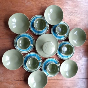 May include: A set of ten green and blue ceramic teacups and saucers. The cups and saucers have a concentric circle design in shades of green and blue.