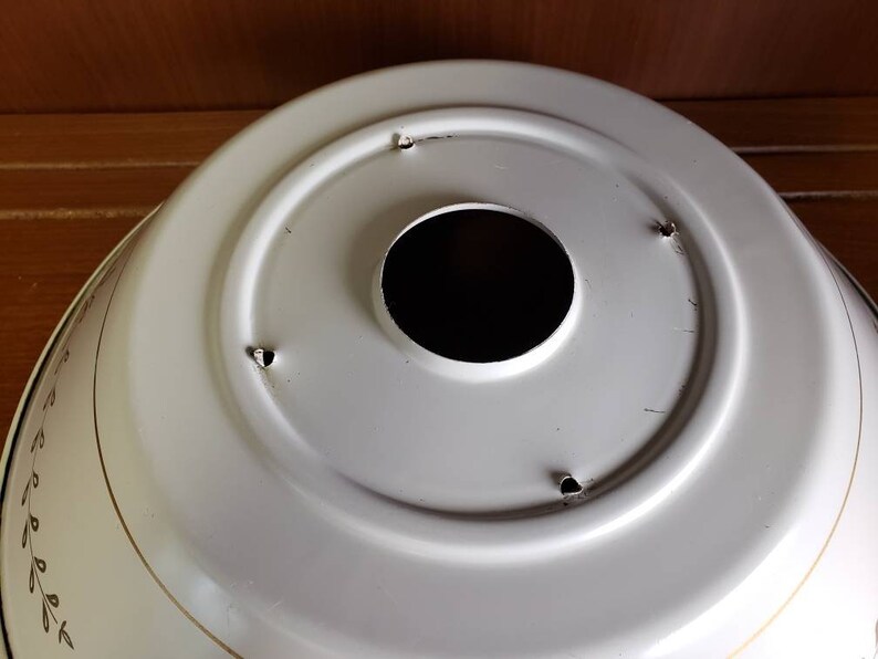 K&ouml;nnte beinhalten: Wei&szlig;e Metall-Deckenleuchte mit rundem, dekorativem Design. Die Leuchte hat ein zentrales Loch f&uuml;r eine Gl&uuml;hbirne und vier kleine L&ouml;cher am Rand.