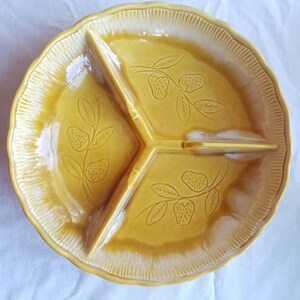 May include: A yellow ceramic divided serving dish with a scalloped edge. The dish has three sections and is decorated with a strawberry vine design.