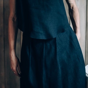 May include: A dark blue linen top and skirt set. The top is sleeveless and the skirt is long and flowing.