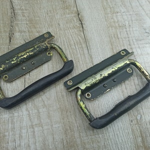 May include: Two vintage metal handles with black rubber grips. The handles are painted green and have a gold finish.