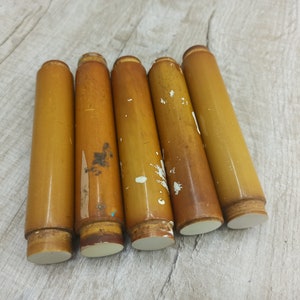 May include: Six wooden furniture legs with a worn, brown finish and white painted tips.