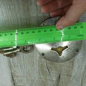 May include: A silver padlock with a keyhole and a key. The padlock is 2.5 inches in diameter. The key is 2 inches long.