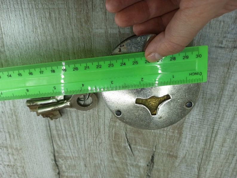 May include: A silver padlock with a keyhole and a key. The padlock is 2.5 inches in diameter. The key is 2 inches long.