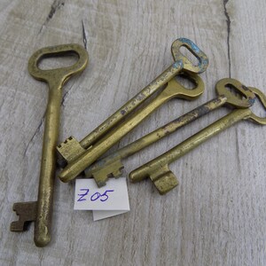 May include: Five antique brass keys with worn edges and a small white tag with the number "205" written in blue ink.