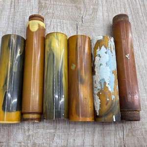 May include: Six brown and yellow patterned cylindrical tubes with a slight variation in colour and pattern.