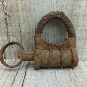 May include: A rusty metal padlock with a round keyhole and a barrel-shaped body. The padlock is made of iron and has a dark brown patina.
