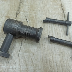 May include: Three metal tools, one with a handle and two with T-shaped handles. The tools are silver and have a worn, aged look.
