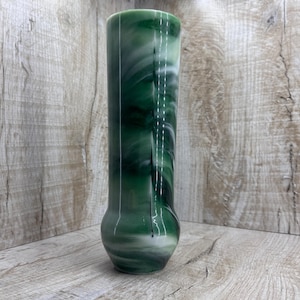 Peut inclure: Un vase cylindrique et élancé avec une base arrondie. Le vase présente un motif tourbillonnant de vert et de blanc, créant un effet marbré. Le vase est en verre ou dans un matériau similaire et convient pour exposer des fleurs ou comme objet décoratif.