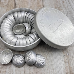 May include: A set of vintage aluminum molds for making candies or chocolates. The molds are in a round container with a lid, and several individual molds are displayed separately. The lid has Cyrillic text and a logo.