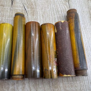 May include: Six round, wooden, decorative, multi-coloured, cylindrical tubes with a glossy finish.
