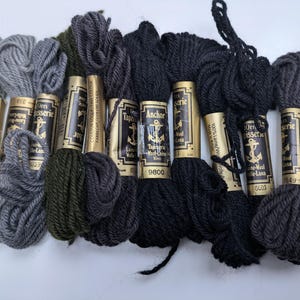 Pode incluir: Oito rolos de l&atilde; Anchor Tapestry em v&aacute;rios tons de verde, cinza e preto. Os rolos s&atilde;o etiquetados com o nome da marca "Anchor Tapestry" e o n&uacute;mero da cor.