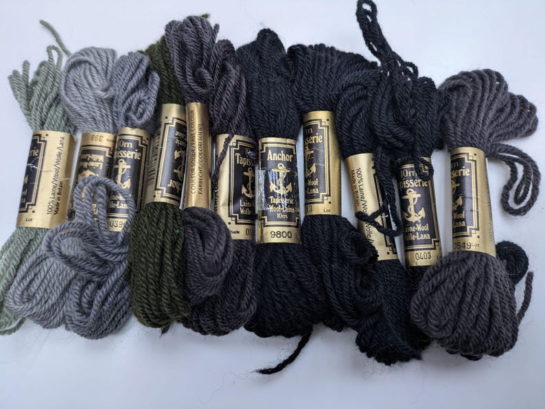 Pode incluir: Oito rolos de l&atilde; Anchor Tapestry em v&aacute;rios tons de verde, cinza e preto. Os rolos s&atilde;o etiquetados com o nome da marca "Anchor Tapestry" e o n&uacute;mero da cor.