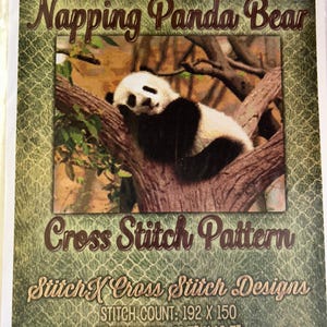 May include: Cross stitch pattern featuring a black and white panda bear sleeping in a tree. The pattern is titled "Napping Panda Bear" and includes the stitch count of 192 x 150 and the design size of 13.7" x 10.7".