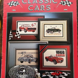 May include: A book titled "Classic Cars" with a red cover and a checkered flag design. The book is part of the RainDrop collection and is numbered 12. The book features cross-stitch patterns of classic cars, including a 1967 Camaro, a 1947 Cadillac, a 1957 Corvette, and a 1966 Cobra.