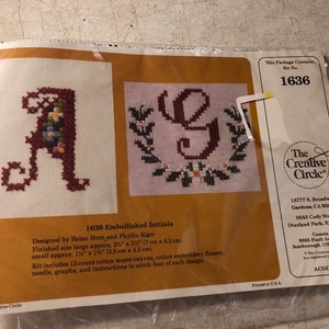 May include: Embellished Initials cross stitch kit with two designs, a floral 'A' and a floral 'G'. The kit includes 12-count cotton waste canvas, cotton embroidery floss, a needle, graphs, and instructions to stitch four of each design. The kit is from The Creative Circle.