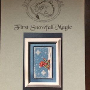 May include: Cross stitch pattern for a winter scene with a red cardinal bird, snowflakes, and a pine tree. The pattern is titled "First Snowfall Magic" and is by Jennifer L. Akman Smith.