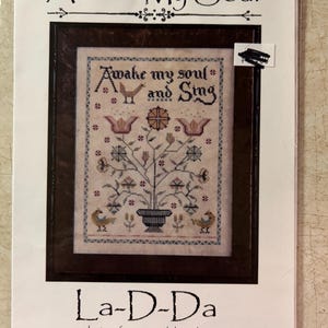 May include: Cross stitch pattern featuring a floral design with birds and the text "Awake my soul and Sing". The pattern is titled "La-D-Da" and is for counted thread.