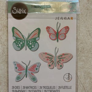 May include: Sizzix Thinlits die set featuring four butterfly designs in shades of pink, green, and red. The package includes the text "JENNAR" and "29 DIES | 29 MATRICES | 29 TROQUELES | 29 FUSTELLE | 29 ВЫРУБКИ | 29 STANZEN | 29 CORTANTES".