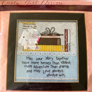 May include: Cross stitch pattern featuring a stack of books with a ribbon tied around them. The pattern includes the text "May your story together have more heroes than villains, more adventure than drama, and may Love always, always win." The pattern is 7 inches by 7 inches.