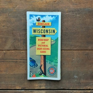 May include: A vintage Sinclair gas station road map and pictorial sight-seeing guide for Wisconsin. The cover features a blue car, a rabbit, and a sign with the text "Sinclair Wisconsin".