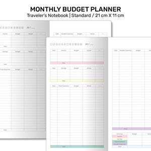 May include: A monthly budget planner notebook with a white cover and gray grid lines. The notebook is labeled "Monthly Budget Planner" and "Traveler's Notebook | Standard / 21 cm x 11 cm".