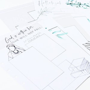 May include: A collection of white paper sheets with various illustrations and text. Some sheets feature line drawings of buildings, furniture, and botanical elements. One sheet has the text "God is within her. She will not fall."