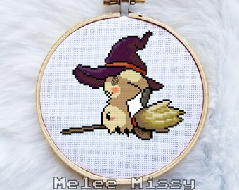 May include: Cross-stitch embroidery hoop with a cute cartoon witch with a purple hat and a broom. The text "Meleee Missy Stitchery" is below the hoop.