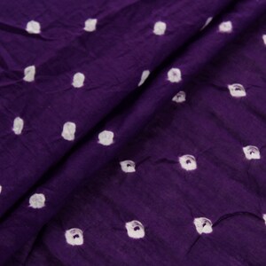 Puede incluir: Tela morada con lunares blancos. La tela tiene un tacto suave y texturizado.