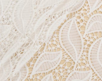 May include: White lace fabric with a delicate leaf pattern. The lace is soft and flowing, with a subtle sheen.