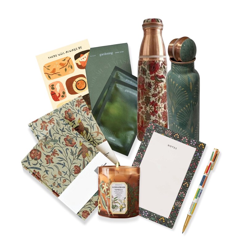 May include: A gift set featuring a variety of items, including a candle, two copper water bottles, a notepad, a pen, and two sets of patterned fabric napkins. The candle is brown with a floral design and the text "Sandalwood Vanilla". The water bottles are copper with floral and geometric patterns. The notepad has a green and white floral border and the text "Notes". The pen is multi-colored and the napkins are green and white with a floral pattern. The set is perfect for a housewarming gift or a special occasion.
