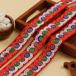 Puede incluir: Borde rojo, blanco y azul con espejos redondos con respaldo plateado. El borde está hecho de hilo de crochet y tiene un borde festoneado.