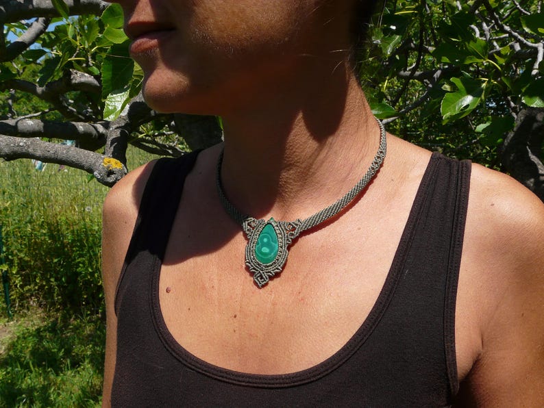 Collana girocollo realizzata a mano in tecnica Macramè da Rasikoserena con pietra naturale verde Malachite naturale, di forma a goccia e taglio cabochon.
Gioiello esoterico di colore grigio/verde anallergico e regolabile in misura grazie alla chiusura scorrevole in legno. Pezzi unici artigianali comodi da indossare, inclusi di confezione regalo.