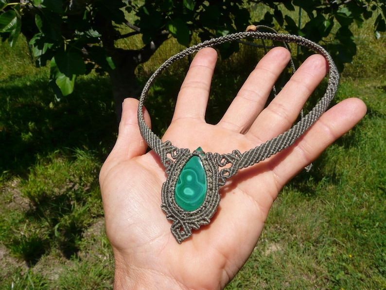 Collana girocollo realizzata a mano in tecnica Macramè da Rasikoserena con pietra naturale verde Malachite naturale, di forma a goccia e taglio cabochon.
Gioiello esoterico di colore grigio/verde anallergico e regolabile in misura grazie alla chiusura scorrevole in legno. Pezzi unici artigianali comodi da indossare, inclusi di confezione regalo.