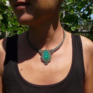 Collana girocollo realizzata a mano in tecnica Macramè da Rasikoserena con pietra naturale verde Malachite naturale, di forma a goccia e taglio cabochon.
Gioiello esoterico di colore grigio/verde anallergico e regolabile in misura grazie alla chiusura scorrevole in legno. Pezzi unici artigianali comodi da indossare, inclusi di confezione regalo.