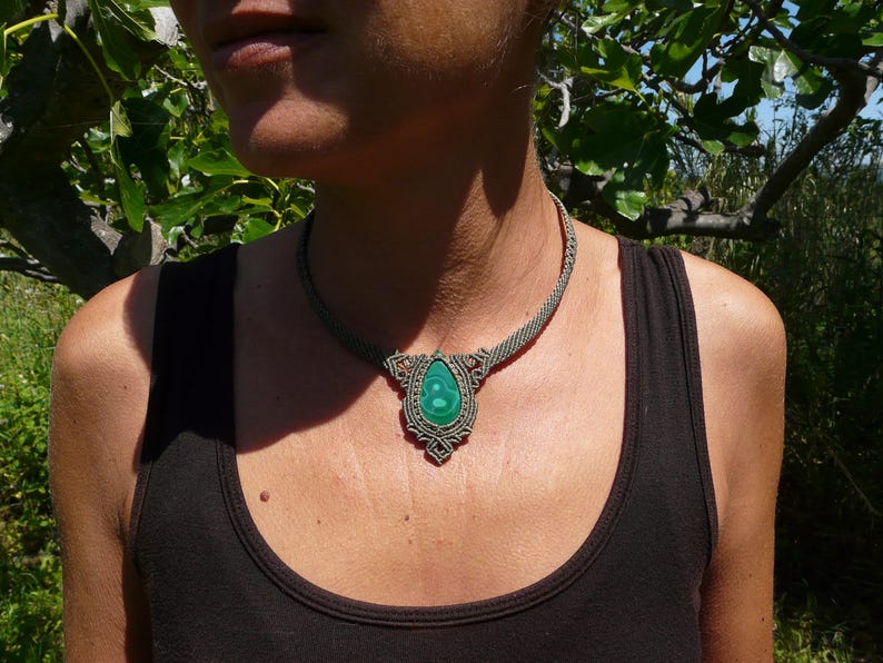 Collana girocollo realizzata a mano in tecnica Macramè da Rasikoserena con pietra naturale verde Malachite naturale, di forma a goccia e taglio cabochon.
Gioiello esoterico di colore grigio/verde anallergico e regolabile in misura grazie alla chiusura scorrevole in legno. Pezzi unici artigianali comodi da indossare, inclusi di confezione regalo.