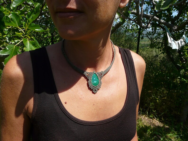 Collana girocollo realizzata a mano in tecnica Macramè da Rasikoserena con pietra naturale verde Malachite naturale, di forma a goccia e taglio cabochon.
Gioiello esoterico di colore grigio/verde anallergico e regolabile in misura grazie alla chiusura scorrevole in legno. Pezzi unici artigianali comodi da indossare, inclusi di confezione regalo.