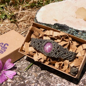 Bracciale a manetta intrecciato a mano in Macramè filato color grigio-verde con pietra naturale Rubino Stella esposto in confezione regalo eco-friendly inclusa.