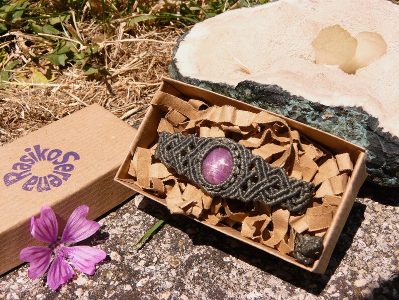 Bracciale a manetta intrecciato a mano in Macramè filato color grigio-verde con pietra naturale Rubino Stella esposto in confezione regalo eco-friendly inclusa.