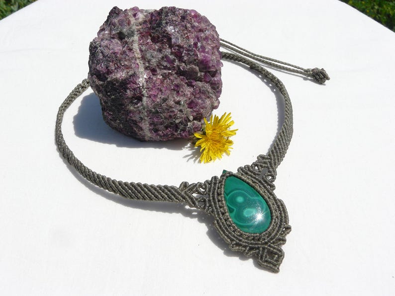 Collana girocollo realizzata a mano in tecnica Macramè da Rasikoserena con pietra naturale verde Malachite naturale, di forma a goccia e taglio cabochon.
Gioiello esoterico di colore grigio/verde anallergico e regolabile in misura grazie alla chiusura scorrevole in legno. Pezzi unici artigianali comodi da indossare, inclusi di confezione regalo.