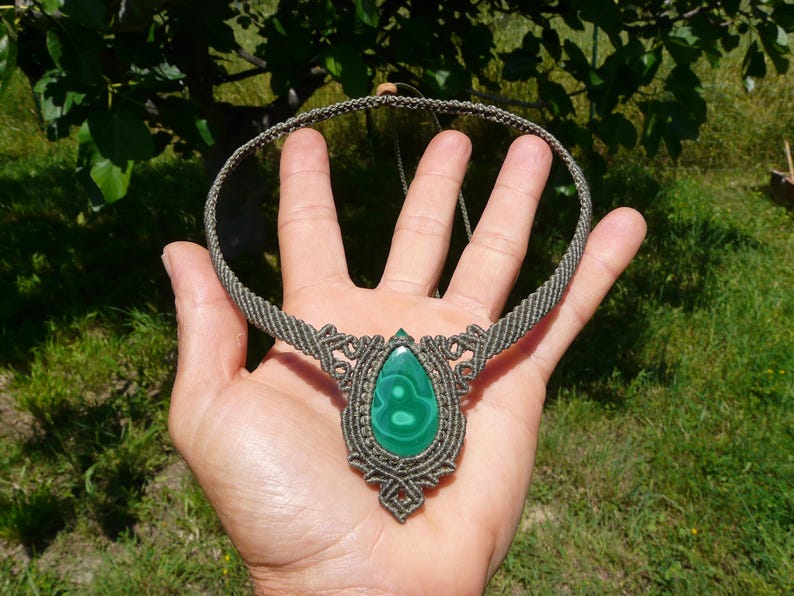 Collana girocollo realizzata a mano in tecnica Macramè da Rasikoserena con pietra naturale verde Malachite naturale, di forma a goccia e taglio cabochon.
Gioiello esoterico di colore grigio/verde anallergico e regolabile in misura grazie alla chiusura scorrevole in legno. Pezzi unici artigianali comodi da indossare, inclusi di confezione regalo.