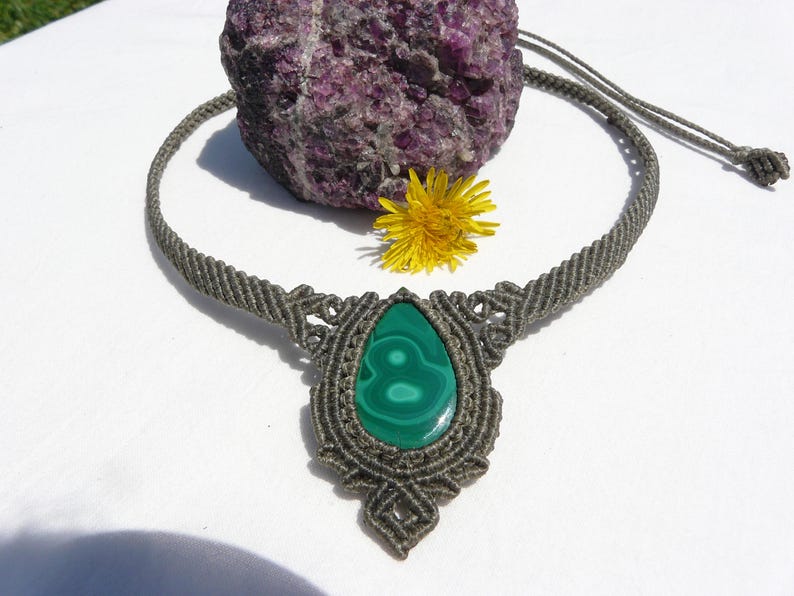 Collana girocollo realizzata a mano in tecnica Macramè da Rasikoserena con pietra naturale verde Malachite naturale, di forma a goccia e taglio cabochon.
Gioiello esoterico di colore grigio/verde anallergico e regolabile in misura grazie alla chiusura scorrevole in legno. Pezzi unici artigianali comodi da indossare, inclusi di confezione regalo.