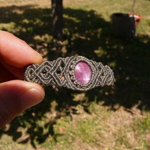 Bracciale a manetta intrecciato a mano in Macramè filato color grigio-verde con pietra naturale Rubino Stella vista lato sinistro primo piano su sfondo naturale