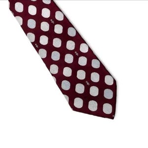 Könnte beinhalten: Eine weinrote Krawatte mit einem sich wiederholenden Muster aus weißen und hellblauen Punkten. Die Krawatte ist abgewinkelt und zeigt das Design und die Textur des Stoffes. Die Punkte sind gleichmäßig verteilt.