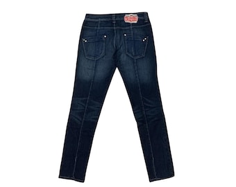 May include: Dark wash denim jeans with a straight leg cut. The jeans have a classic five-pocket design, with decorative stitching and rivets. A red and white label is visible on the back waistband. The jeans are displayed against a white background.