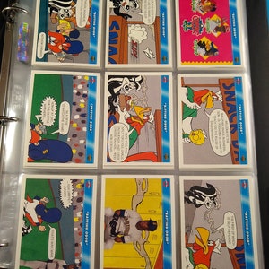 May include: A collection of trading cards featuring cartoon characters from the Looney Tunes franchise. The cards are arranged in a binder and feature various scenes and characters, including Bugs Bunny, Daffy Duck, and Tweety Bird. The cards are part of a set called "Batting Odor".