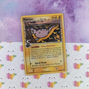 May include: A Mantine Pokémon trading card with a yellow border. The card features a cartoon illustration of Mantine, a light purple and yellow creature. Text includes "Mantine", "Power Circulation", and "Spiral Drain".