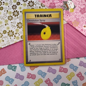 Può includere: Una carta da gioco di Pokemon gialla e bianca con il testo "TRAINER" e "Devolution Spray". La carta mostra un flacone spray giallo con un ugello bianco e una nuvola di fumo bianco che esce dall'ugello. Il testo sulla carta recita: "Scegli 1 dei tuoi Pokemon in gioco e uno stadio di evoluzione. Scarta tutte le carte di evoluzione di quello stadio o di uno stadio superiore attaccate a quel Pokemon. Quel Pokemon non è più addormentato, confuso, paralizzato, avvelenato o qualsiasi altra cosa che potrebbe essere il risultato di un attacco (come se lo avessi fatto evolvere)."