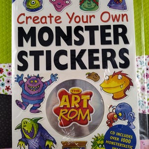 Könnte beinhalten: Ein Buch mit dem Titel "Erstelle deine eigenen Monster-Sticker" mit einer CD-ROM mit über 1000 Monsterbildern. Der Umschlag zeigt bunte Comic-Monster mit verschiedenen Gesichtsausdrücken.